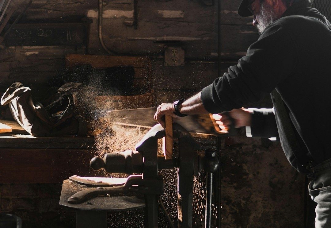 Handwerker bearbeitet Holz in einer staubigen Werkstatt